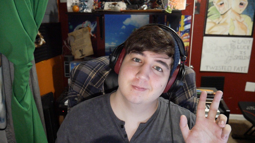 Bodhi Ferguson with headphones and henley shirt, peace sign, in a room with posters and a keyboard.
